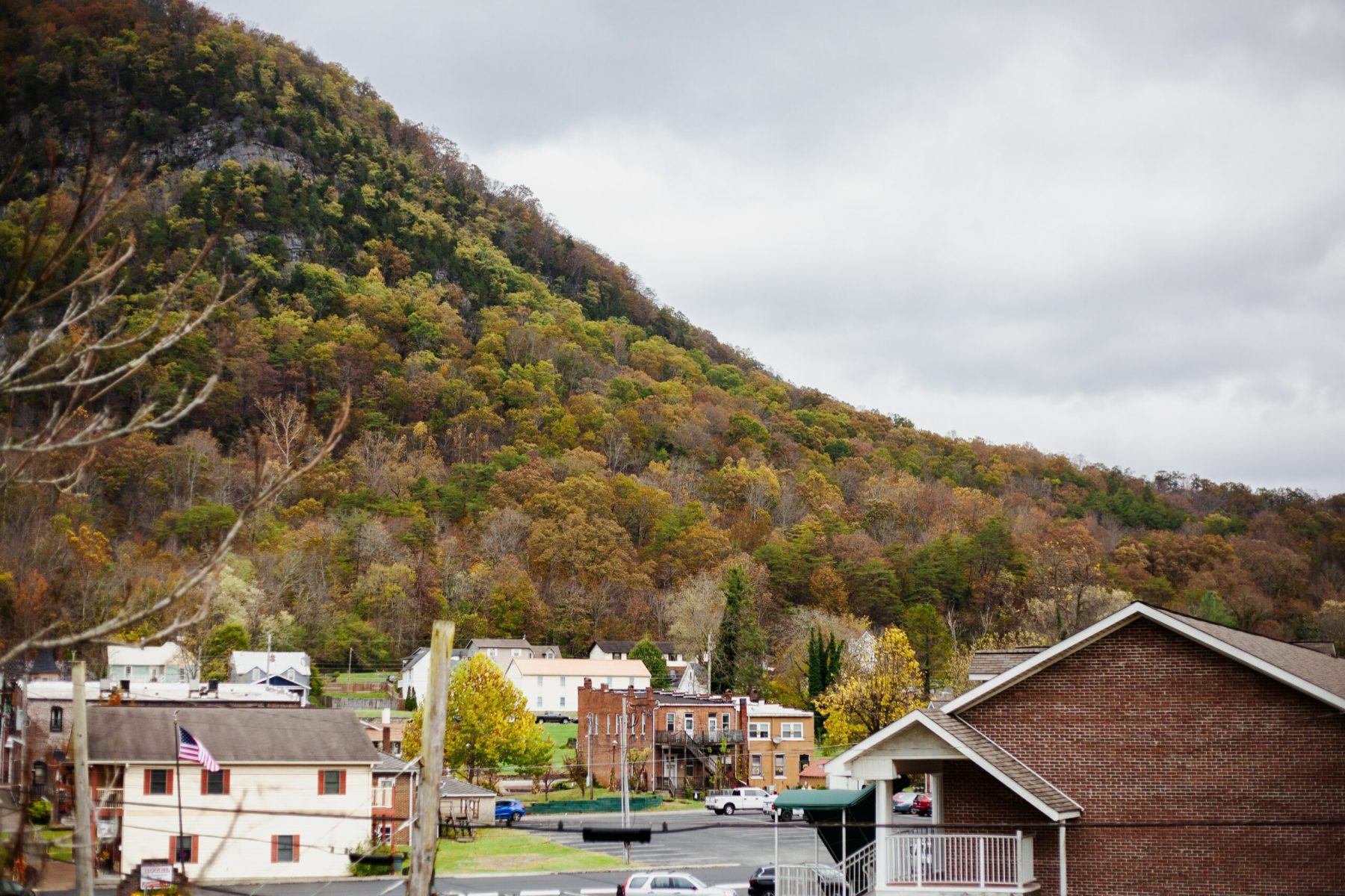 An Appalachian town with a variety of houses and buildings. There is a fall mountain scape in the distance.